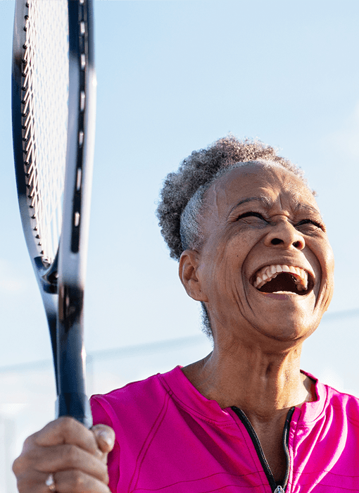 mature woman in pink playing tennis