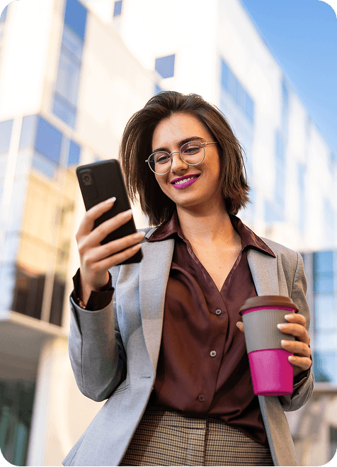 A person using their phone and drinking coffee